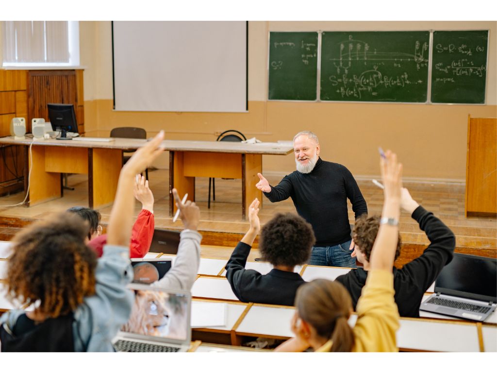 講義中に手を挙げる学生たちと講師