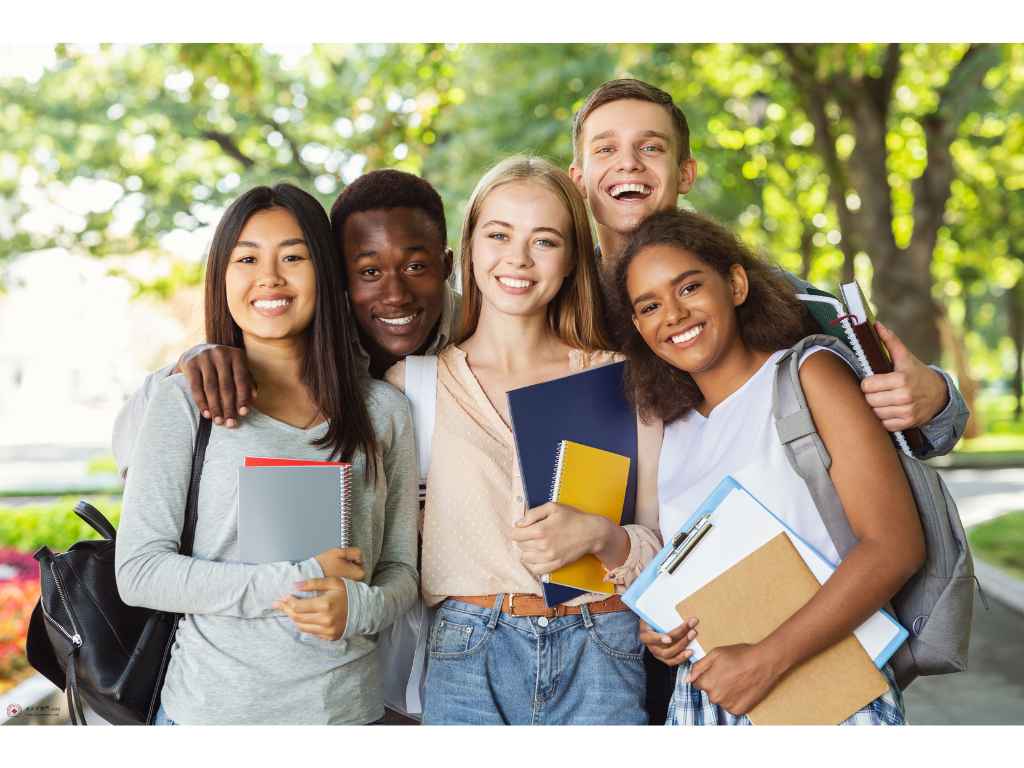 5人の学生がノートを抱えながら集まっている様子